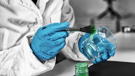 Forensic Evidence examination.  Police laboratory analyst examining glass from a crime scene,...