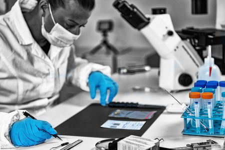 Forensic Science in Lab. Forensic technician examining bullet casing