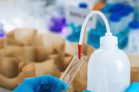 Soil Samples Testing Laboratory. Woman biologist in white coat pouring water in soil sample.の写真素材
