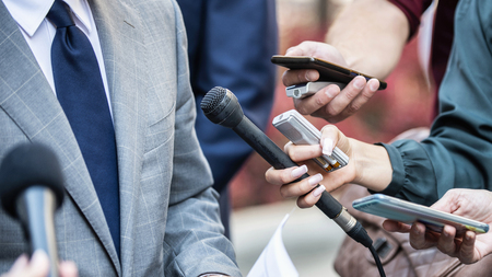Media Interview - journalists with microphones interviewing formal dressed politician or businessman.の写真素材