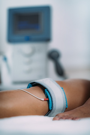 TENS, Transcutaneous Electrical Nerve Stimulation in Physical Therapy. Therapist Positioning Electrodes onto Patient's Kneeの写真素材