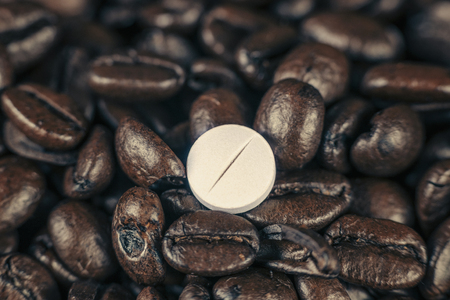 Caffeine supplement pill and roasted coffee beansの写真素材