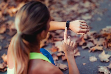 Woman Checking Progress on Smart Watch after Outdoor Trainingの写真素材