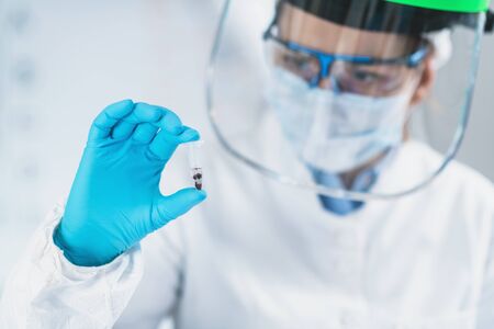 Ancient DNA Analysis. Female scientist holding micro tube with sample in ancient DNA laboratory