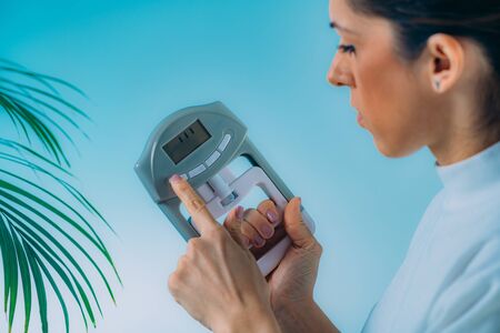 Woman Using Digital Hand Grip Dynamometer