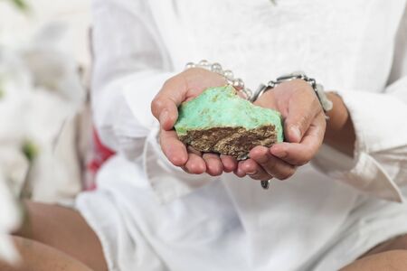 Female crystal healing therapist hand holding green Chrysoprase crystal. Chakra healing treatment with crystals.の写真素材