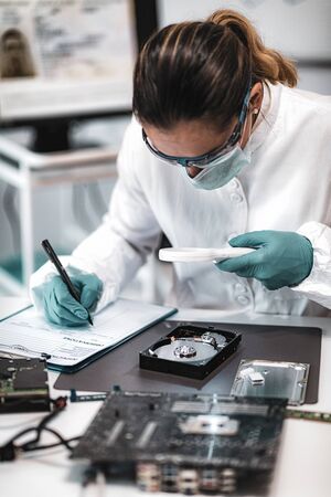 Forensic Science Investigator Examining Computer Hard Drive. Digital Forensic Science Concept.