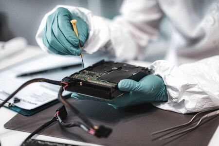 Forensic Science Investigator Examining Computer Hard Drive. Digital Forensic Science Concept.