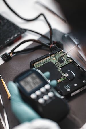 Digital Forensic Science. Police Forensic Analyst Examining Computer Hard Drive.