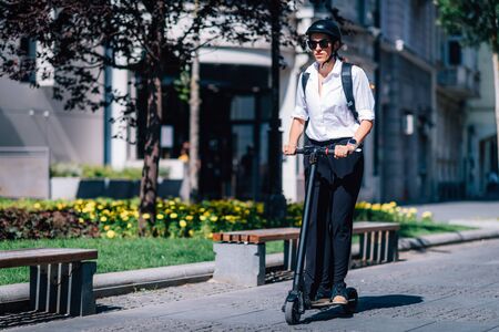 Businesswoman Riding an Electric Scooter in The Park.の写真素材
