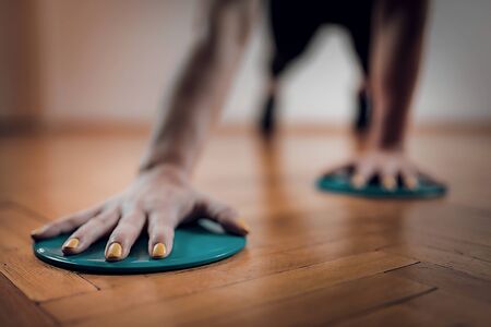 Female Athlete Exercising with Sliding Discs. Focus on Arms.の写真素材