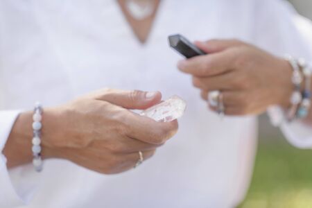 Being in Balance. Self-care wellbeing practice outdoors. Balancing energy with black and white crystal wands. の写真素材