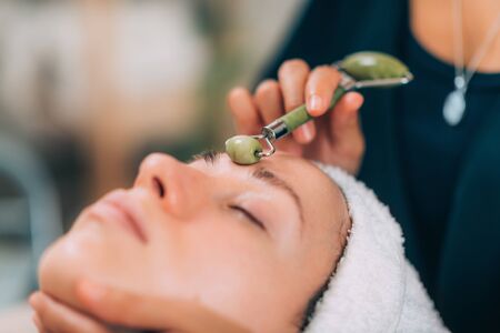 Guasha face lymph draining massage with jade stone rollerの写真素材