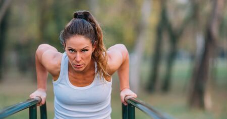 Woman Exercising on Parallel Bars in the Park.