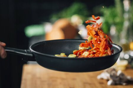 Young chef frying fresh vegetables. Motion blur の写真素材