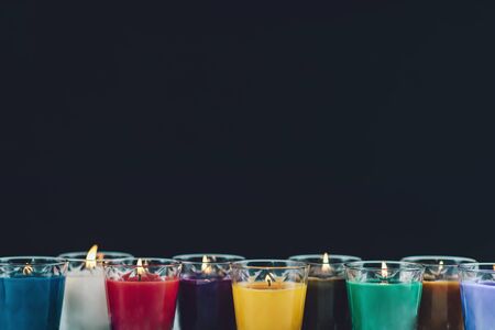 Scented Candles. Flaming aromatic candles on a white table. Black background and copy space for text. の写真素材