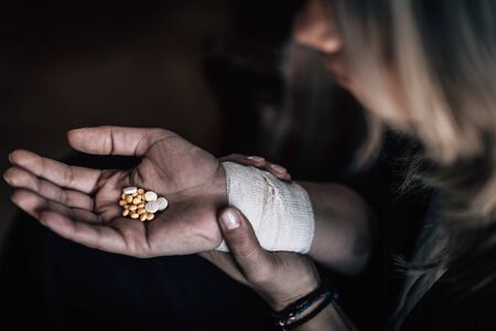 Dark Suicidal Woman Holding Number of Pills in Handの写真素材
