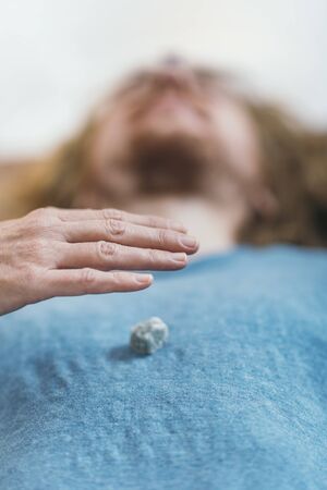 Crystal therapy.  Man lying on massage table, receiving healing with gems placed on body chakrasの写真素材