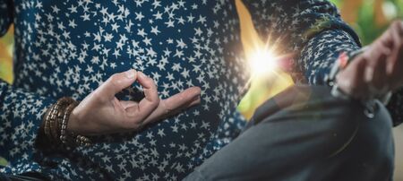 Gyan Mudra or Chin Mudra. Hand gesture holding fingers in Gyan Mudra for self-healing, promoting consciousness, physical and mental health. Practitioner sitting in lotus position, meditating.の写真素材