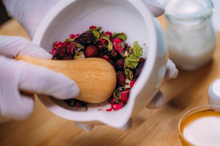 Grinding Herbs and Flowers Using Mortar and Pestle. Homemade Cosmetic Cream Preparation