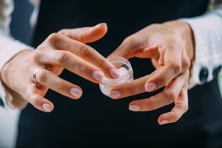 Woman Applying Homemade Hand Cream onto her Handsの写真素材