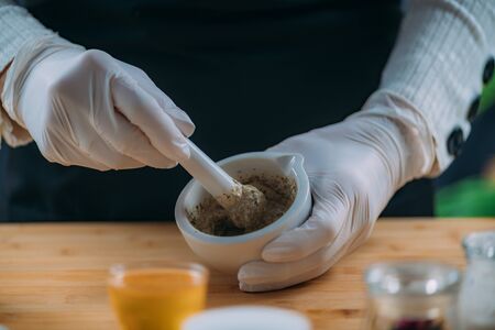 DIY Cream at Home - Grinding Herbs and Flowers Using Mortar and Pestle. Homemade Cosmetic Cream Preparationの写真素材