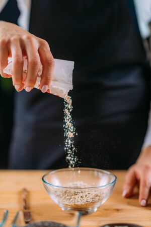 Adding oats into the bowl to make oatmealの写真素材