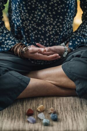 Meditating in Lotus Pose. Female hands in lap, palms facing upwards. Nurturing energy meditation.の写真素材