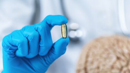 Placebo Effect Concept. Female doctor holding model of brain and placebo supplement pill, explaining the placebo effect healing phenomenonの写真素材