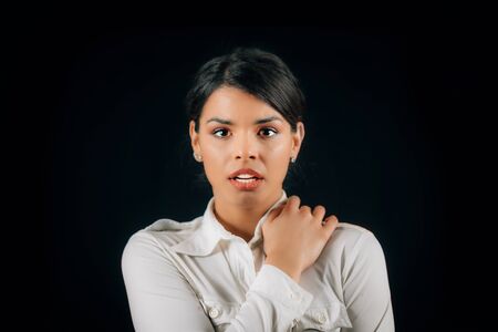 Emotion Fear. Face of a beautiful fearful young woman, expressing fear, studio portrait, black backgroundの写真素材