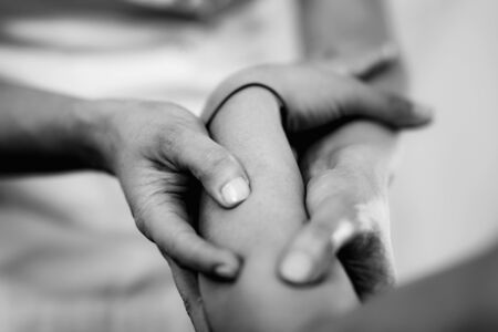Physiotherapist massaging female patient with injured arm. Sports injury treatment.の写真素材