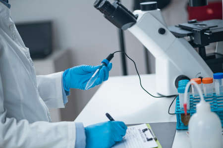 Organic agricultural product quality testing in certified laboratory. Scientist measuring pH of the...