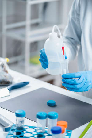 Analyzing Plant Samples for Presence of Pesticides in Farming Products. Pouring Water into Test Tube...