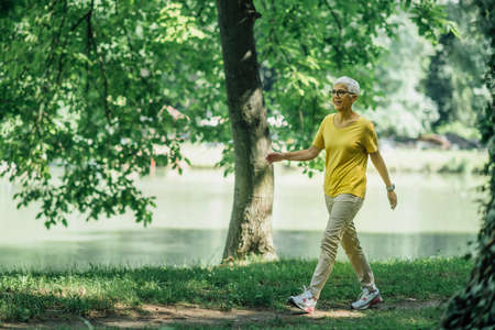 Mature woman enjoying walking exercise by the lakeの写真素材