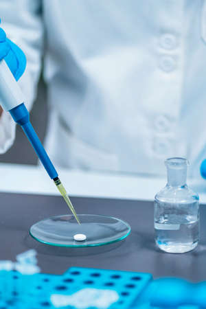 Psychedelic drug LSD therapy research, scientist preparing small doses of LSD in laboratory for an...