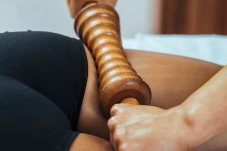 Madero therapy back thigh muscle massage with wooden rolling pin or battledoreの写真素材