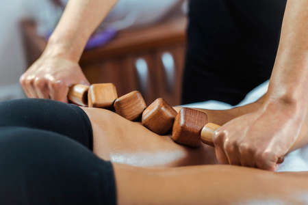 Madero therapy back thigh muscle massage with wooden rolling pin or battledoreの写真素材