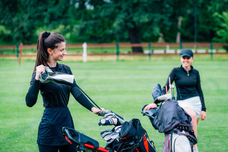 Two young ladies playing golf, having funの写真素材
