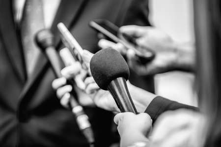Media Interview - journalists with microphones interviewing formal dressed politician or businessman.の写真素材