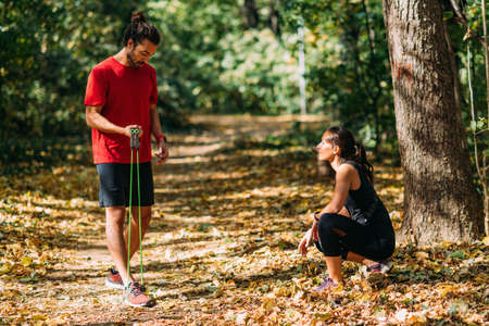 Young Couple Exercising with Elastic Resistance Band Outdoors in the Parkの写真素材