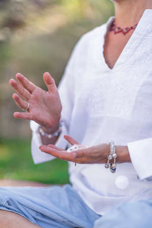 Female crystal healing therapist meditating, manifesting abundance with white selenite crystal. Energy workの写真素材