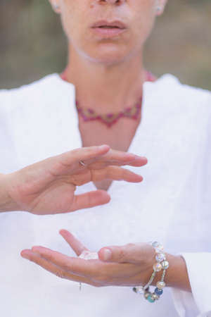 Female crystal healing therapist meditating, manifesting abundance with white selenite crystal. Energy workの写真素材
