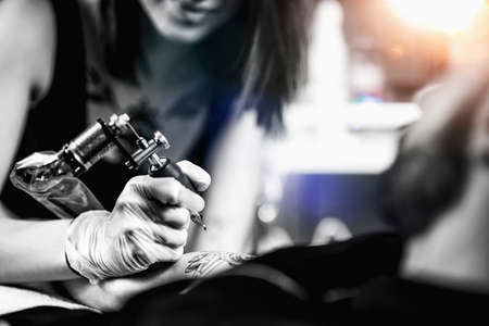 Professional female tattooist working in a tattoo studioの写真素材