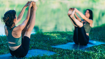Yoga Women by The Water. Boat Poseの写真素材