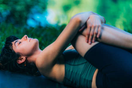 Yoga Woman by The Water. Wind Relieving Pose.