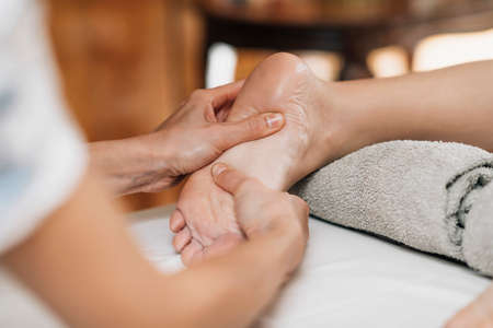 Ayurvedic Reflexology Foot Massage, Ayurveda practitioner pressing meridian points on female foot.の写真素材