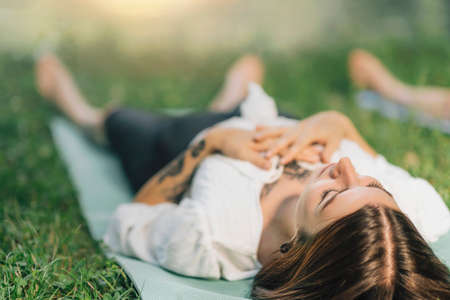 Meditating by the water. Young woman lying by the water and meditatingの写真素材
