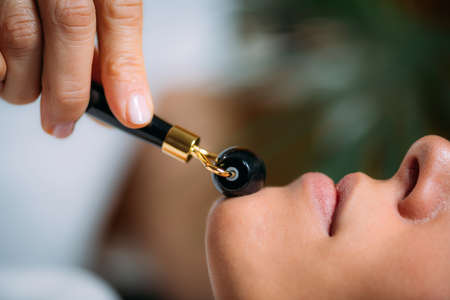 Guasha Face Lymphatic Drainage Massage with Jade Stone Rollerの写真素材