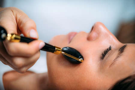Guasha Face Lymphatic Drainage Massage with Jade Stone Rollerの写真素材