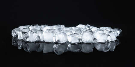Ice cubes on a black reflective backgroundの写真素材